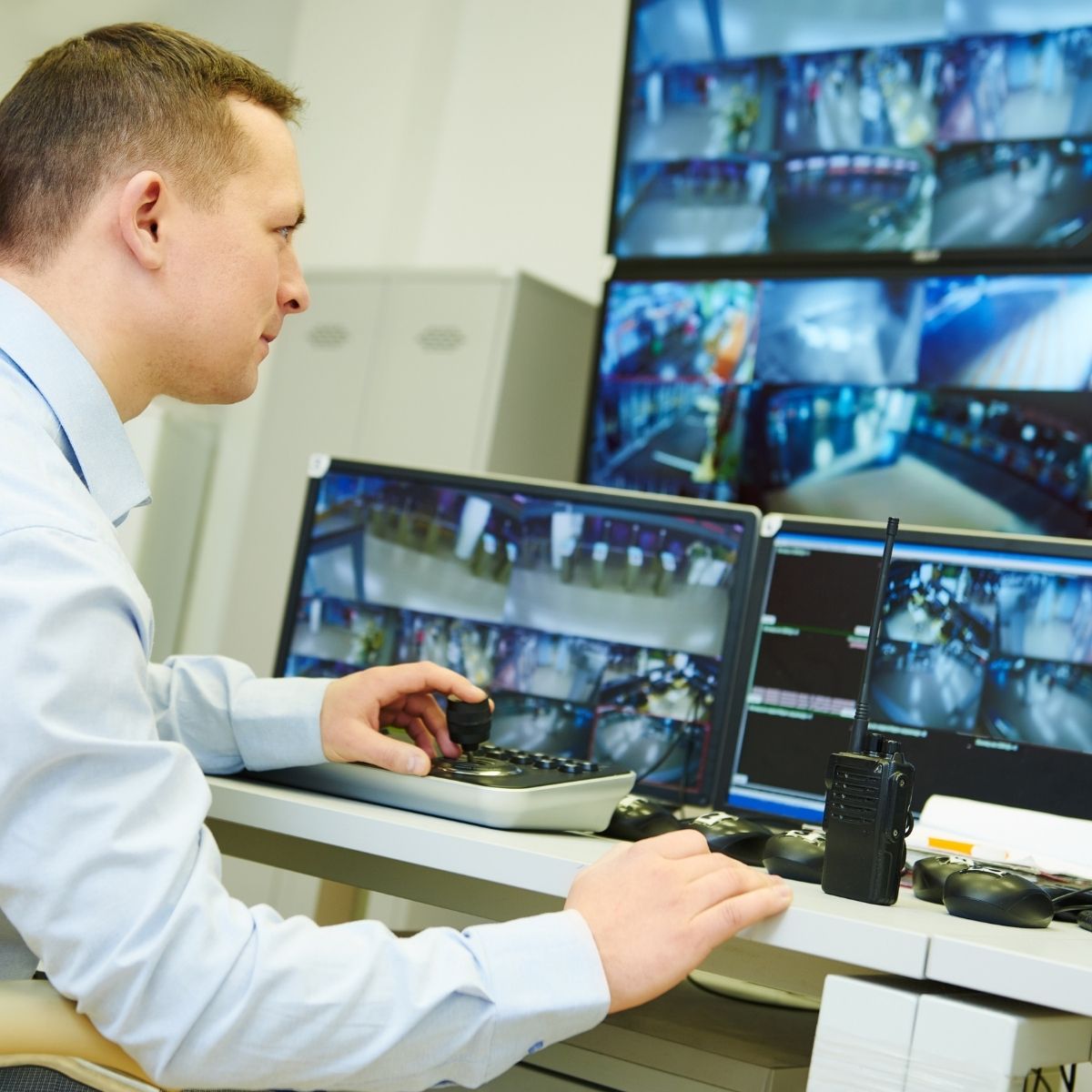 Agent de sécurité privée surveillant les écrans de vidéosurveillance dans un centre de contrôle. Agent de sécurité privée en télésurveillance.